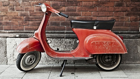 Красный скутер у кирпичной стены