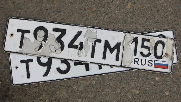 Старый номерной знак на автомобиль с ободранным покрытием